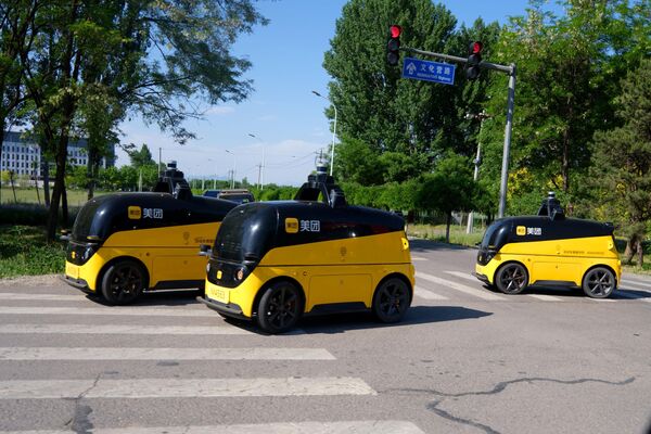 Беспилотные автомобили доставки проводят дорожные испытания 7 мая 2024 года в Пекине. - Sputnik Грузия