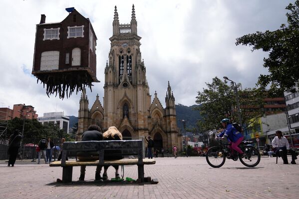 Инсталляция аргентинского художника Леандро Эрлиха, изображающая дом со свисающей из-под него корневой системой, висит в воздухе в парке Лурдес в рамках первой художественной биеннале в Боготе. - Sputnik Грузия