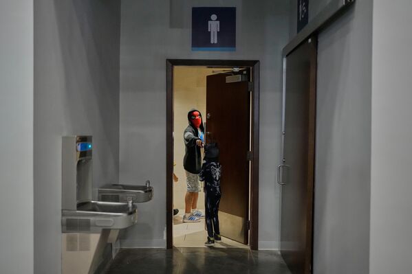 Мужчина в маске Человека-паука разговаривает со своим сыном, выходя из ванной комнаты во время Comic-Con в Панама-Сити. - Sputnik Грузия