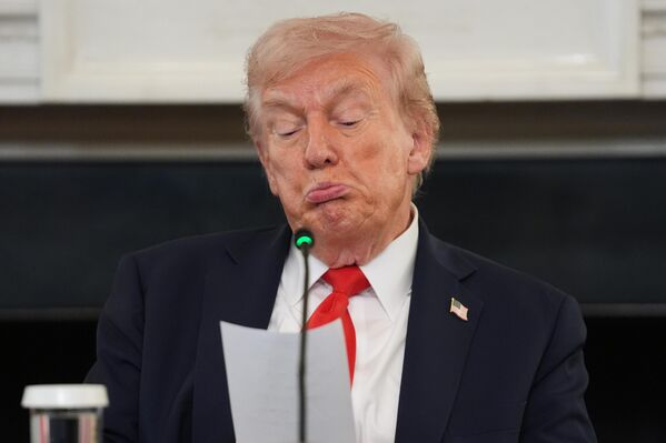 Президент США Дональд Трамп читает записку, переданную ему госсекретарем Марко Рубио во время круглого стола по борьбе с экстремизмом в государственной столовой Белого дома. - Sputnik Грузия