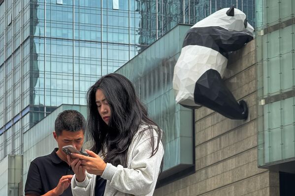 Пешеходы возле знаменитой скульптуры большой панды на внешней стене торгового центра Chengdu International Finance Square в Китае. Пешеходы возле знаменитой скульптуры большой панды на внешней стене торгового центра Chengdu International Finance Square в Китае. - Sputnik Грузия