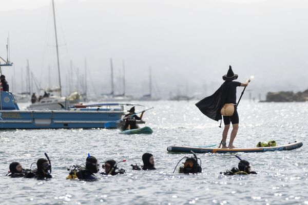 აშშ-ში ჯადოქრების ფესტივალზე აკვალანგისტები თვალს ადევნებენ კოსტიუმში გამოწყობილ ნიჩბოსანს. აშშ-ში ჯადოქრების ფესტივალზე აკვალანგისტები თვალს ადევნებენ კოსტიუმში გამოწყობილ ნიჩბოსანს. - Sputnik საქართველო