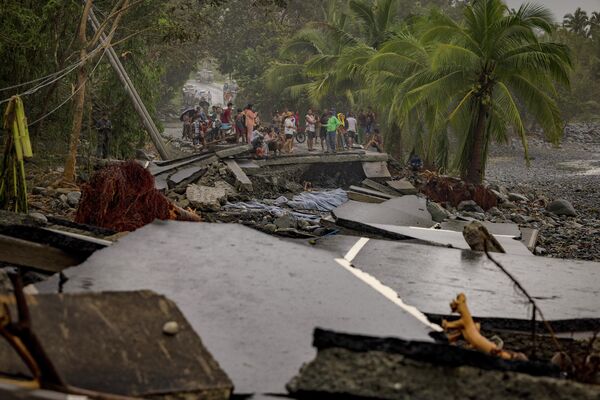 Жители осматривают шоссе, разрушенное во время супертайфуна "Фунг-вонг". - Sputnik Грузия