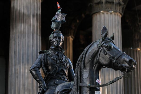 Голубь, читающий газету, на вершине статуи герцога Веллингтона у Галереи современного искусства в Глазго. Голубь, читающий газету, на вершине статуи герцога Веллингтона у Галереи современного искусства в Глазго. - Sputnik Грузия