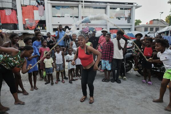 Люди прыгают через скакалку в приюте для семей, пострадавших от бандитизма, в Порт-о-Пренсе, Гаити. Люди прыгают через скакалку в приюте для семей, пострадавших от бандитизма, в Порт-о-Пренсе, Гаити. - Sputnik Грузия