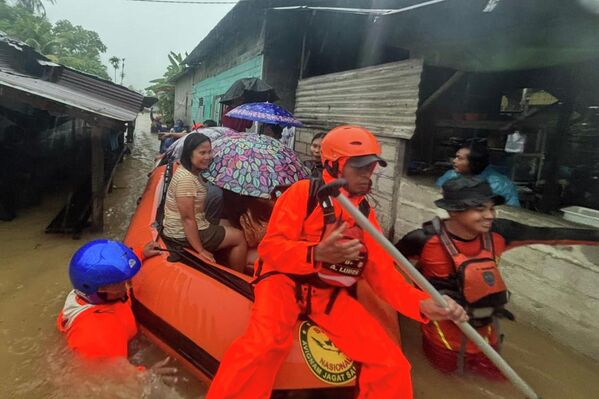 Спасатели на резиновой лодке эвакуируют жителей из затопленного дома в Индонезии. - Sputnik Грузия