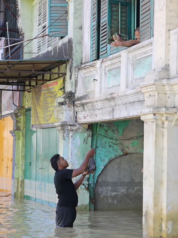 Передача продуктов во время наводнения в Индонезии. - Sputnik Грузия