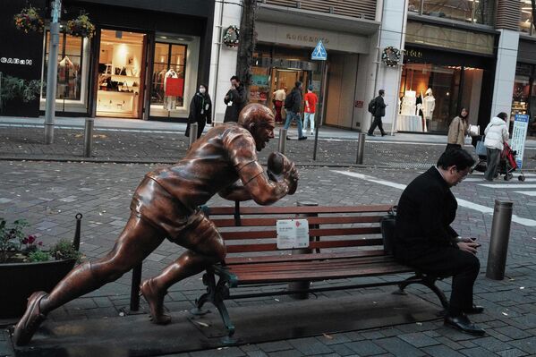 მამაკაცი ქანდაკების გვერდით სკამზე ზის, იაპონია. - Sputnik საქართველო