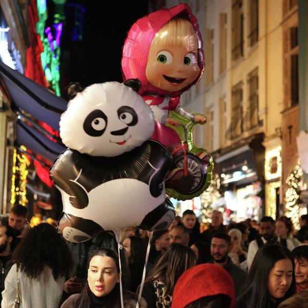 Рождественский Брюссель и огромные воздушные шары в виде героев мультфильмов "Кунг-Фу Панда" и "Маша и медведь" в руке местной жительницы. - Sputnik Грузия