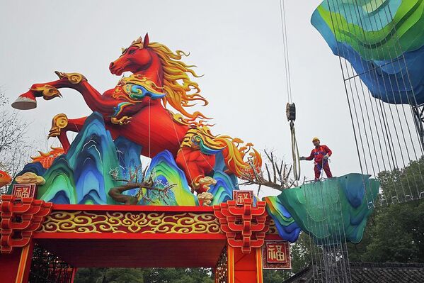 Рабочий в китайском Нанкине устанавливает гигантский фонарь в виде лошади, чтобы встретить наступающий китайский Новый год 2026. - Sputnik Грузия