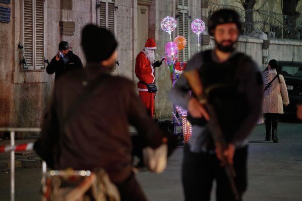 Мужчина в костюме Санта-Клауса продает рождественские украшения в христианском районе Кассаа в Дамаске. - Sputnik Грузия