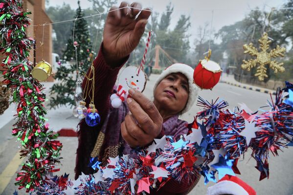 Женщина расставляет украшения для предстоящих рождественских торжеств в соборе Святого Иоанна в Пешаваре, Пакистан. - Sputnik Грузия
