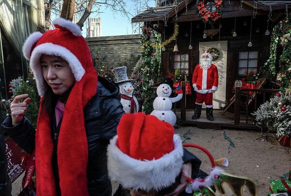 Женщина и ребенок в праздничных шляпах на рождественской ярмарке во французском стиле в Пекине, Китай.  - Sputnik Грузия