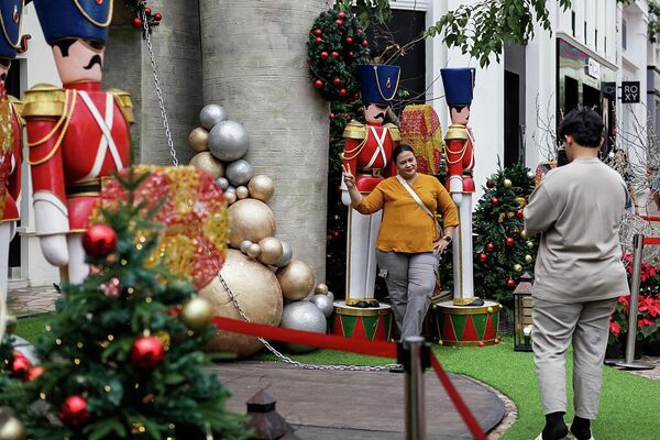 Посетители фотографируются на фоне праздничных рождественских украшений в торговом центре Paris Van Java в Бандунге, Индонезия. - Sputnik Грузия