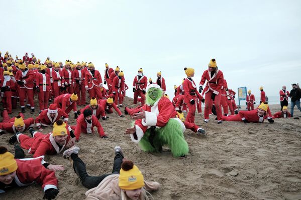 ნიდერლანდებში ყოველწლიური Surfin' Santas ღონისძიების ფარგლებში, სანტა-კლაუსის კოსტიუმებში ჩაცმული სერფერები ჩრდილოეთის ზღვის ყინულიან წყლებში შესასვლელად ემზადებიან. - Sputnik საქართველო