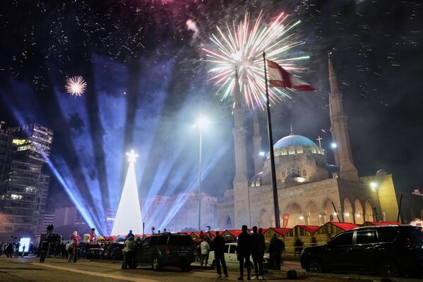 Зрители наблюдают за фейерверком в честь зажжения гигантской рождественской елки, установленной перед мечетью Мухаммеда аль-Амина на Площади Мучеников в центре Бейрута. - Sputnik Грузия