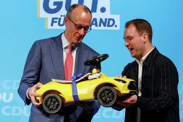 გერმანიის კანცლერ ფრიდრიხ მერცს გერმანიის ქრისტიან-დემოკრატიული კავშირის ლიდერის საარჩევნო კამპანიის დროს  Pfenning Group-ის თანამშრომელმა შვილებისთვის აჩუქრად მანქანა გადასცა. - Sputnik საქართველო