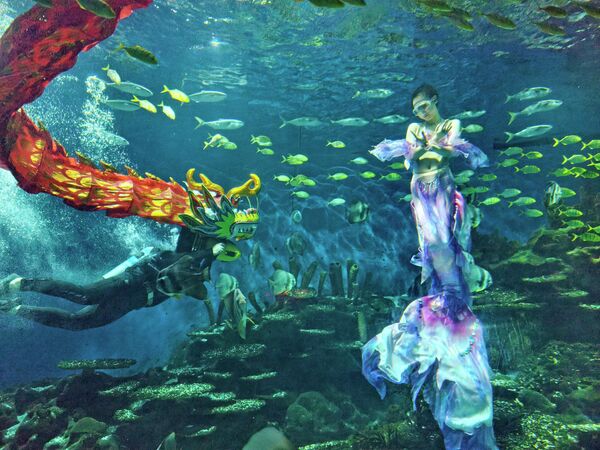 Дайвер исполняет подводный танец дракона в Уханьском океанариуме. - Sputnik Грузия