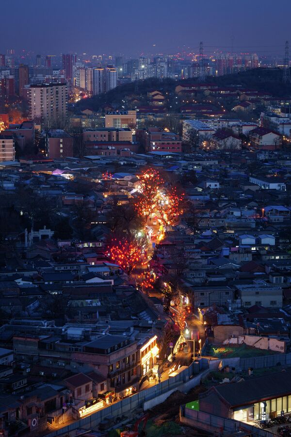 Городские огни освещают улицу, украшенную красными фонарями в преддверии новогодних праздников по лунному календарю. - Sputnik Грузия