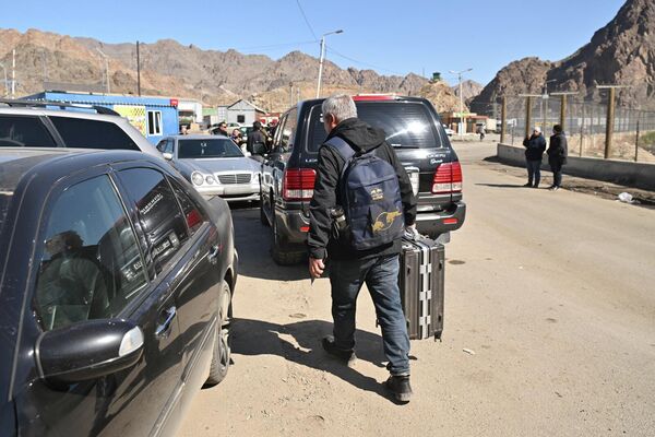 Люди готовятся к дальнейшей дороге после пересечения границы - Sputnik Грузия