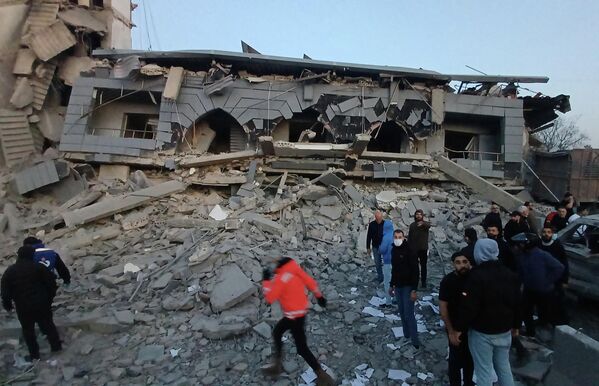 Спасатели собрались перед разрушенным центром ливанской исламской группировки после нанесенного по зданию израильского удара, в южном портовом городе Сидон, Ливан. - Sputnik Грузия
