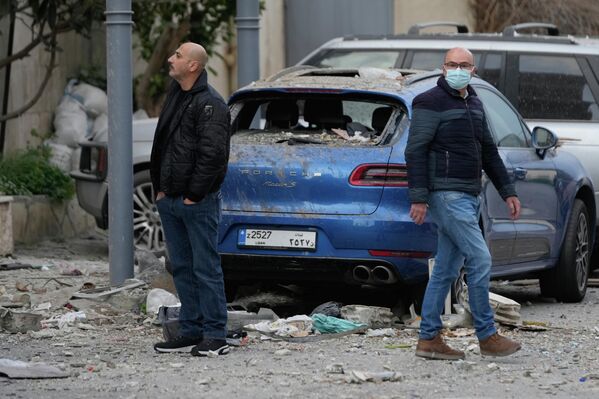 Жители осматривают руины отеля, пострадавшего от израильского авиаудара в Хазмие, к востоку от Бейрута. - Sputnik Грузия