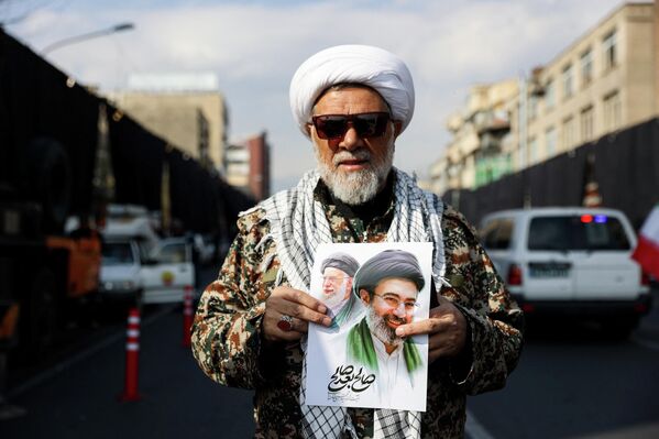 Мужчина держит плакат с изображением нового верховного лидера Ирана Моджтабы Хаменеи. - Sputnik Грузия