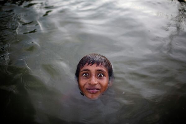  ბავშვი ბანგლადეშის ქალაქ დაკას გარეუბანში, ალუმინის გადამამუშავებელი ქარხნის მახლობლად, ბურიგანგას მდინარეში ცურავს. - Sputnik საქართველო