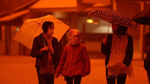 Люди в масках во время песчаной бури на острове Крит (1 апреля 2026). Ираклион - Sputnik Грузия