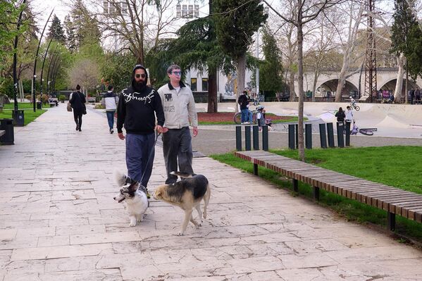 Хозяева выводят на прогулку своих питомцев, которые тоже радуются солнцу. - Sputnik Грузия