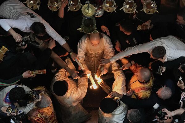 იერუსალიმის მაცხოვრის აღდგომის ტაძრის შუაგულში გადმოსული ცეცხლი, ჯერ მთელს ეკლესიაში, შემდეგ კი მთელ მსოფლიოში ვრცელდება.  - Sputnik საქართველო
