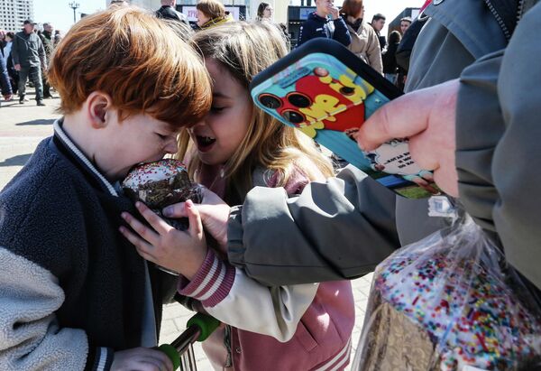 Раздача куличей на Пасхальном фестивале на Площади Славы перед Спасо-Преображенским кафедральным собором в Хабаровске во время празднования Пасхи. - Sputnik Грузия