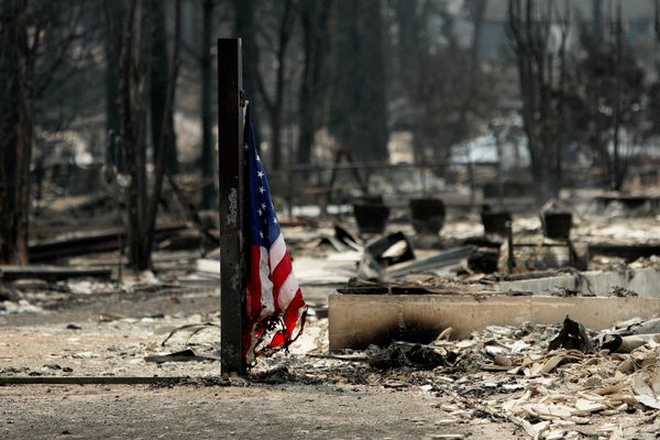 Американский флаг у сгоревшего строения в жилом районе Уэстгейт в Спокане. - Sputnik Грузия