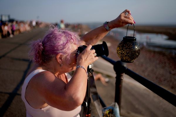 Женщина фотографирует частичное солнечное затмение на пляже Кросби в Ливерпуле, Англия. - Sputnik Грузия