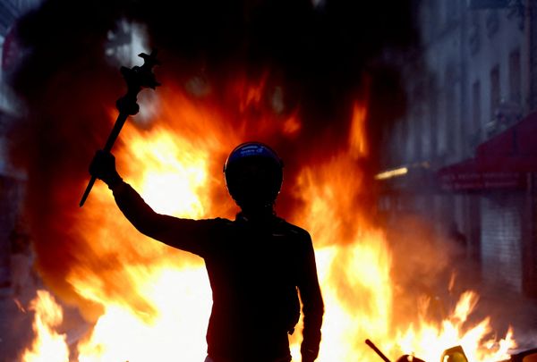 Участник протеста на фоне горящей баррикады из мусорных баков. - Sputnik Грузия