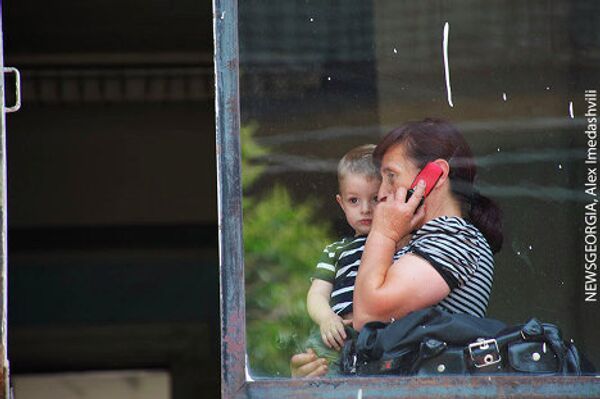 Многие из матерей-беженцев до последнего момента со своими детьми оставались в здании, уже в пустующих помещениях - спасаясь от жаркого июльского солнца, и общаясь по телефону со своими родными и близкими.  - Sputnik Грузия