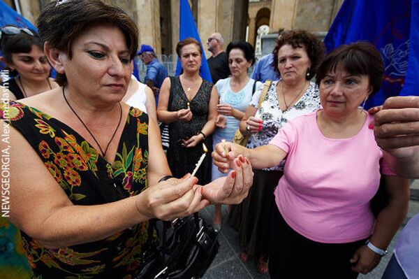 Держа в руках горящие свечи, участники акции почтили минутой молчания память погибших шахтеров. - Sputnik Грузия