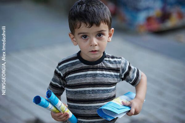 На фото - ребенок, беженец из Абхазии, который держит в руках буклеты, переданные ему участниками акции. Может, у него будет мирное будущее?  - Sputnik Грузия