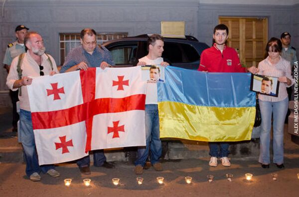 На земле у здания посольства были расставлены горящие свечи в память о погибшем журналисте. Участие в акции приняли тбилисские участники группы грузино-украинской дружбы на Facebook. - Sputnik Грузия