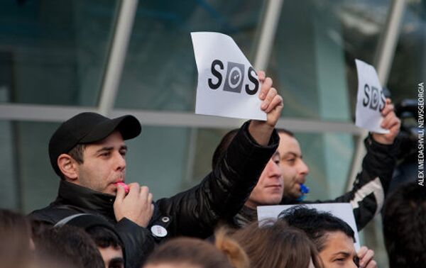 В руках участники акции держали стилизованное изображение слова S.O.S. - центральная буква O выполнена в форме логотипа Маэстро. - Sputnik Грузия