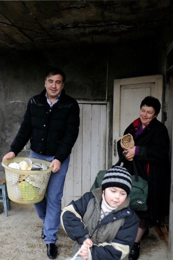 Михаил Саакашвили помогает беженцам выносить вещи из старых помещений. - Sputnik Грузия