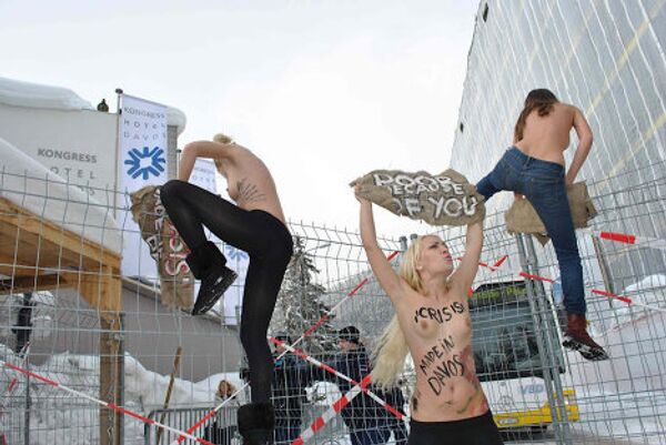 Участницы акции FEMEN в Давосе перелезают через забор, чтобы попасть на закрытую охраняемую территорию. - Sputnik Грузия