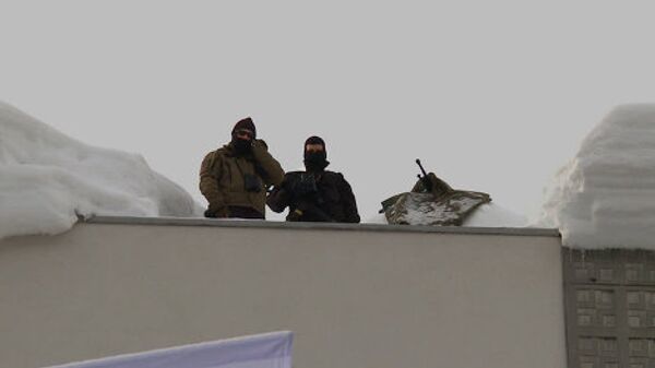 Охранники с крыши здания наблюдают за акцией FEMEN в Давосе. - Sputnik Грузия
