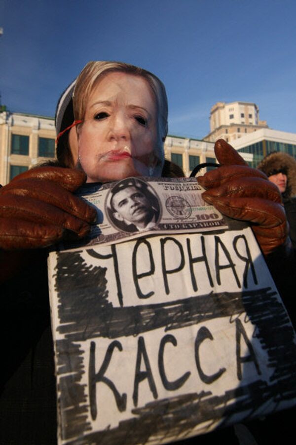 Девушка в маске Хиллари Клинтон держит в руках нарисованные доллары и коробку с надписью Черная касса во время митинга оппозиции За честные выборы на площади имени Г.Тукая в Казани. - Sputnik Грузия