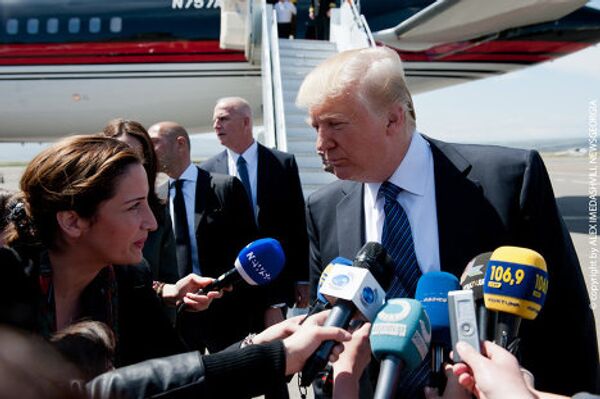 Дональд Трамп пытается расслышать вопрос журналиста из-за шума от двигателей самолетов в тбилисском аэропорту.  - Sputnik Грузия