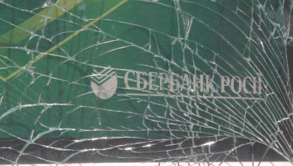 Рабочие собирали осколки выбитых взрывом стекол отделения Сбербанка в Киеве - Sputnik Грузия