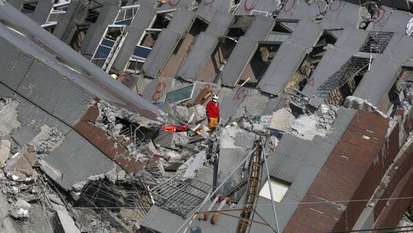 Спасатель на развалинах 17-этажного дома, разрушенного землетрясением в Тайнане на юге Тайваня. - Sputnik Грузия