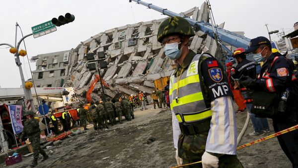 Солдат участвует в спасательной операции на территории у разрушенного землетрясением 17-этажного здания в Тайнане, Тайвань. - Sputnik Грузия