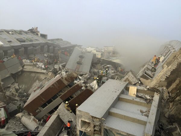 Спасатели работают на месте разрушенного землетрясением 17-этажного здания в Тайнане, Тайвань. - Sputnik Грузия