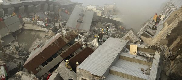 Спасатели работают на месте разрушенного землетрясением 17-этажного здания в Тайнане, Тайвань. - Sputnik Грузия